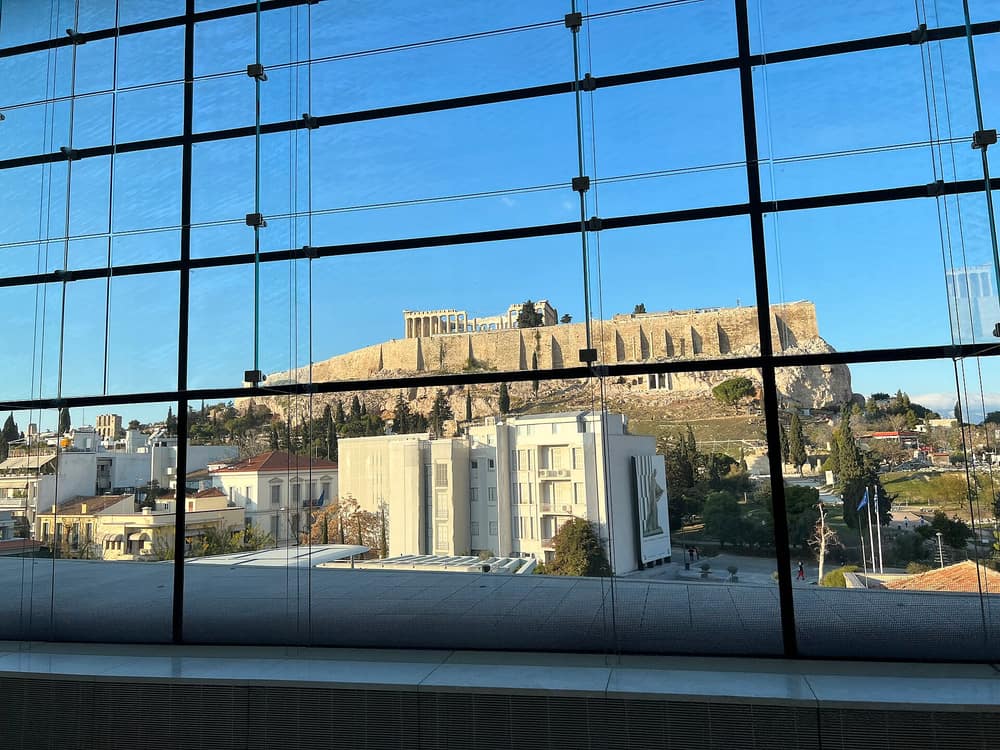 Acropolis Museum tickets open a glass hall with the Acropolis hill in view beyond the window