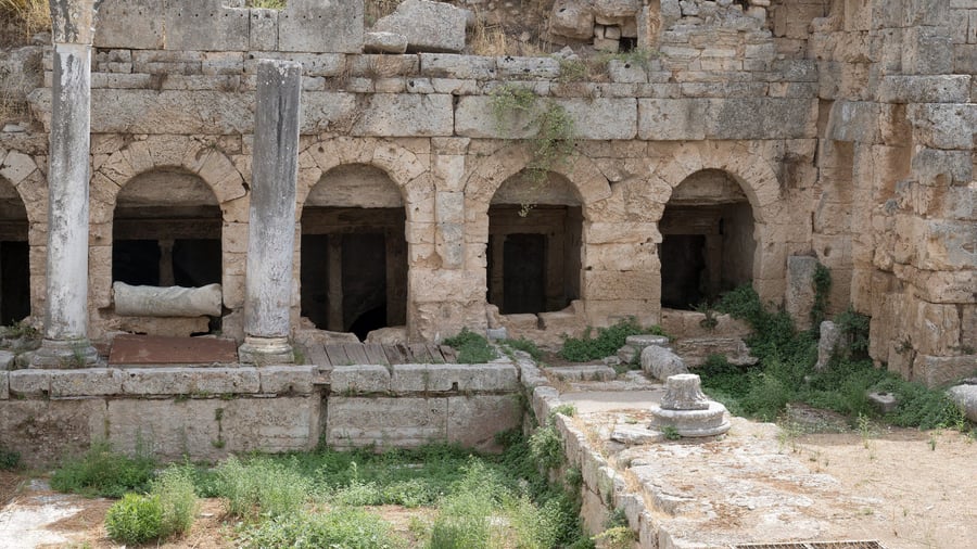 An Ancient Corinth tour stops at the arched chambers of the Peirene fountain, the spring of the Roman city