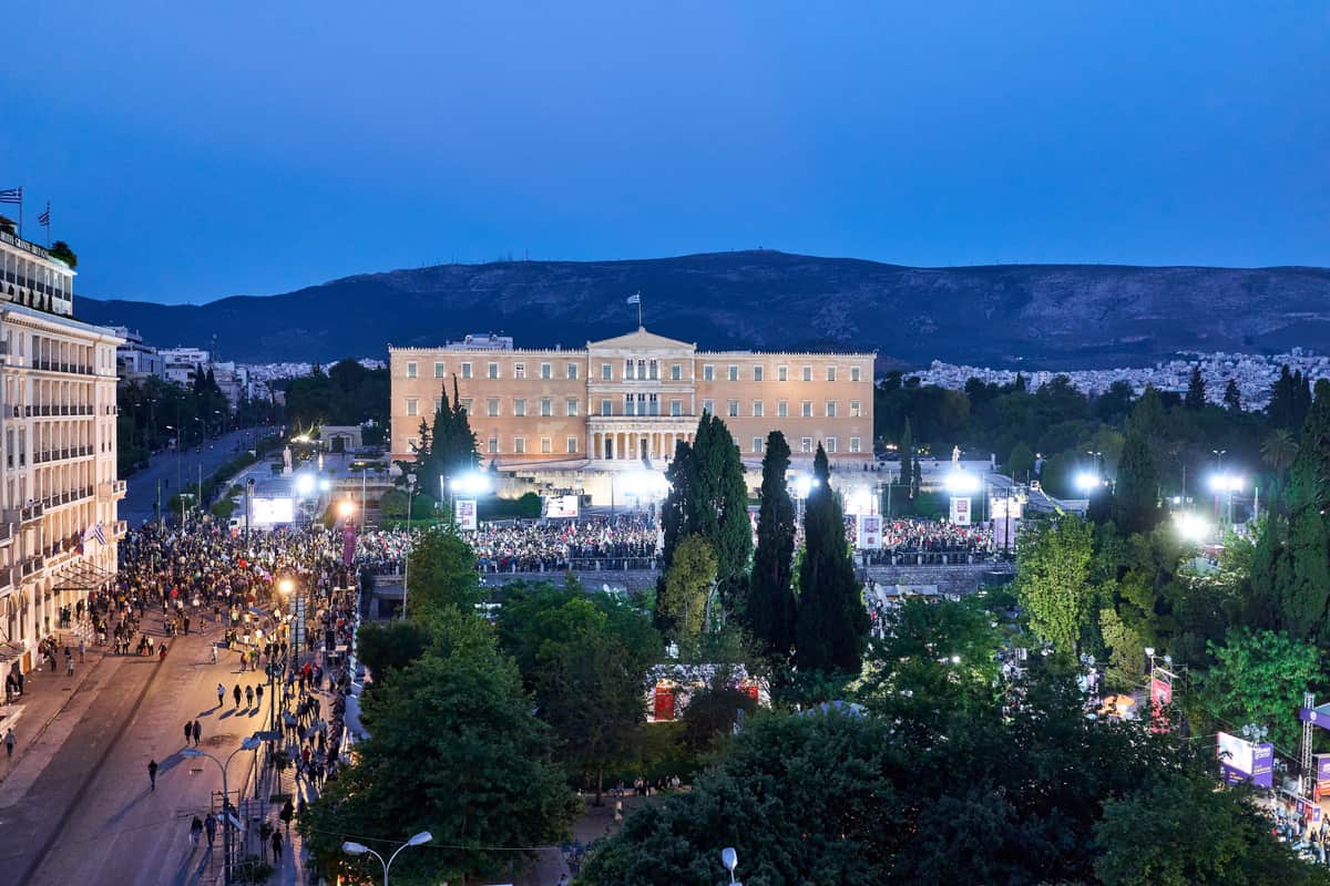 An Athens hop on hop off bus passes Syntagma Square and the Hellenic Parliament