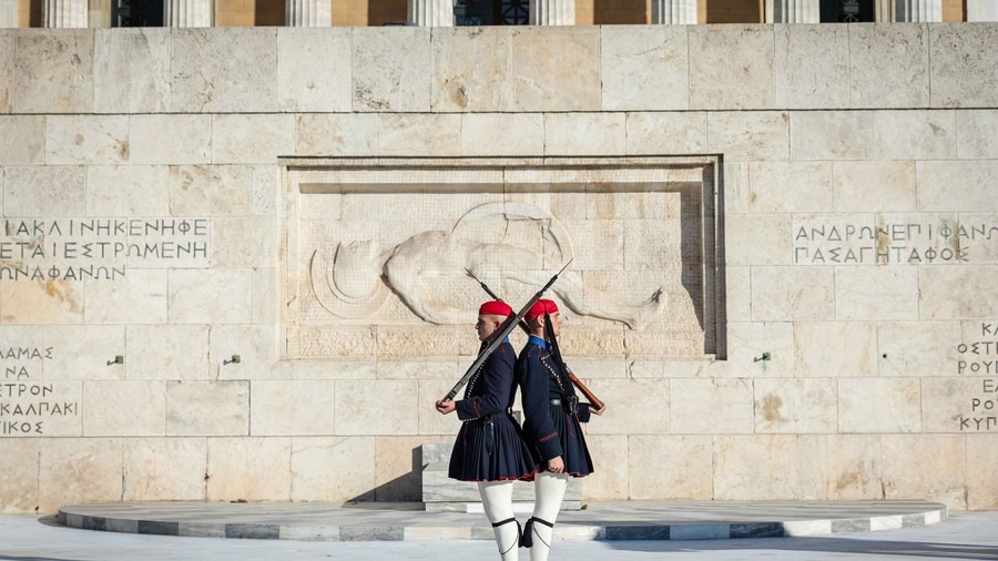An Athens photo tour frames two Evzones of the Presidential Guard in front of the Tomb of the Unknown Soldier at Syntagma