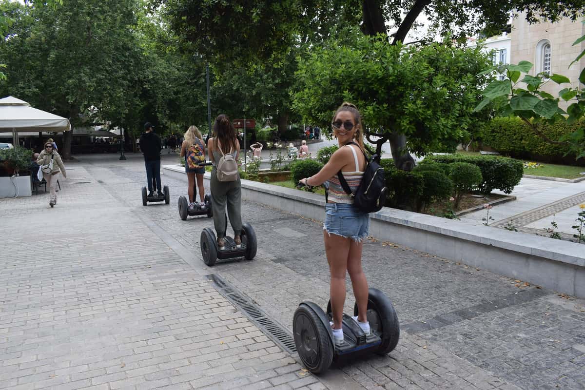 An Athens segway tour rides in a line along a paved square in the centre of Athens
