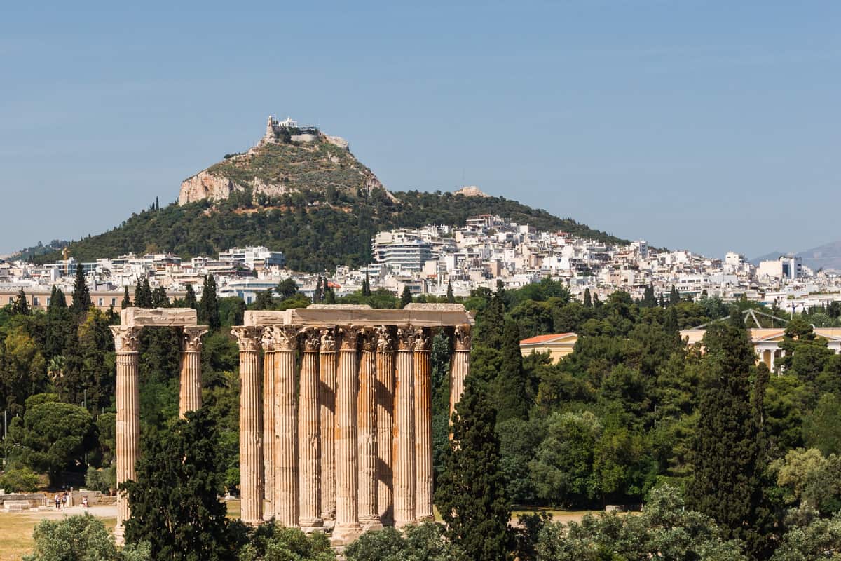 An Athens shore excursion passes the Temple of Olympian Zeus, with the hill of Lycabettus rising behind