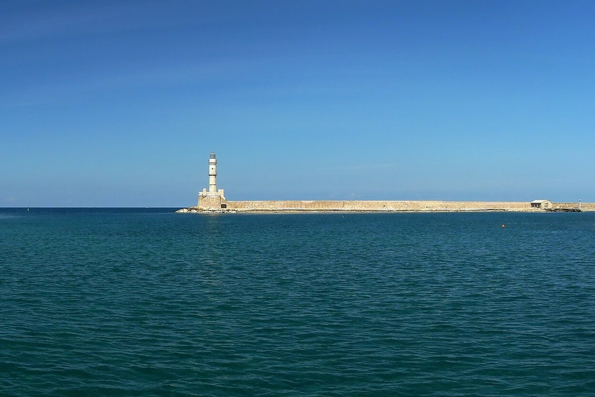 A Chania boat trip passes the Venetian lighthouse at the entrance of the old harbour of Chania