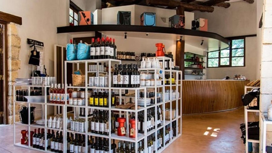 Shelves of local wine bottles in a stone winery tasting room visited on a Chania wine tour