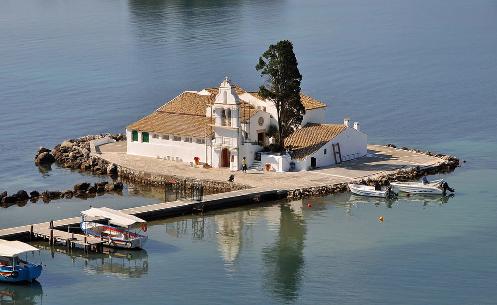 A Corfu boat trip passes the white Vlacherna monastery on its small causeway