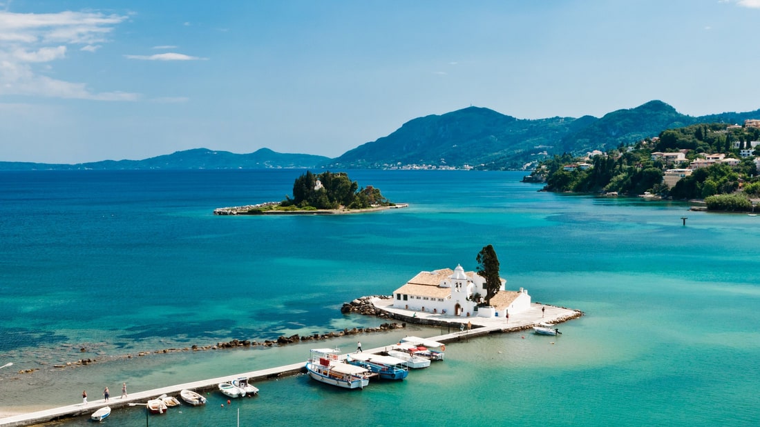 A Corfu tour looks down from Kanoni on the Vlacherna monastery and Mouse Island in the turquoise lagoon