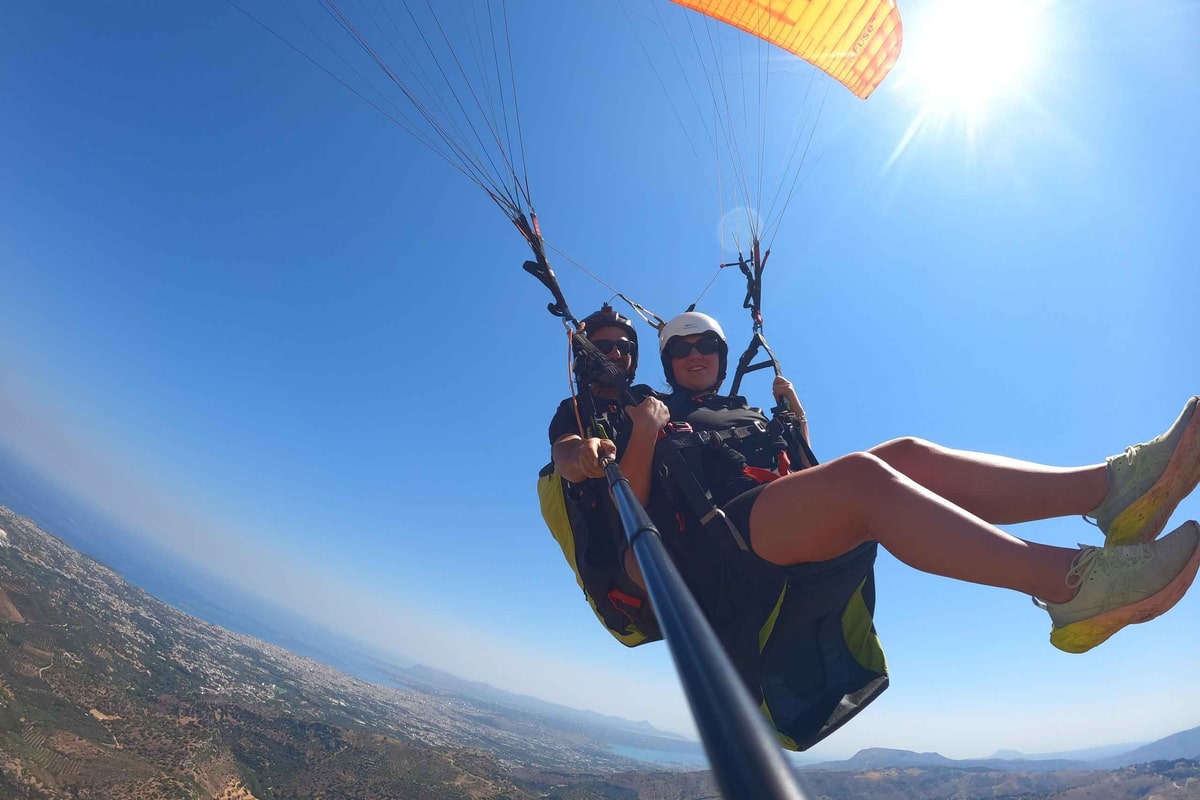 Crete paragliding tandem flight high above the north coast of Crete under a bright sun