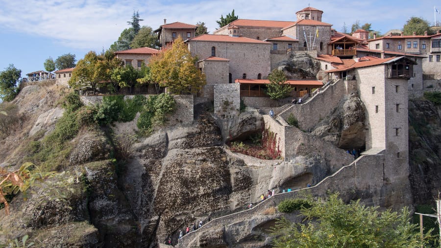 A Delphi Meteora tour climbs the stone stairway to the Great Meteoron monastery on its rock