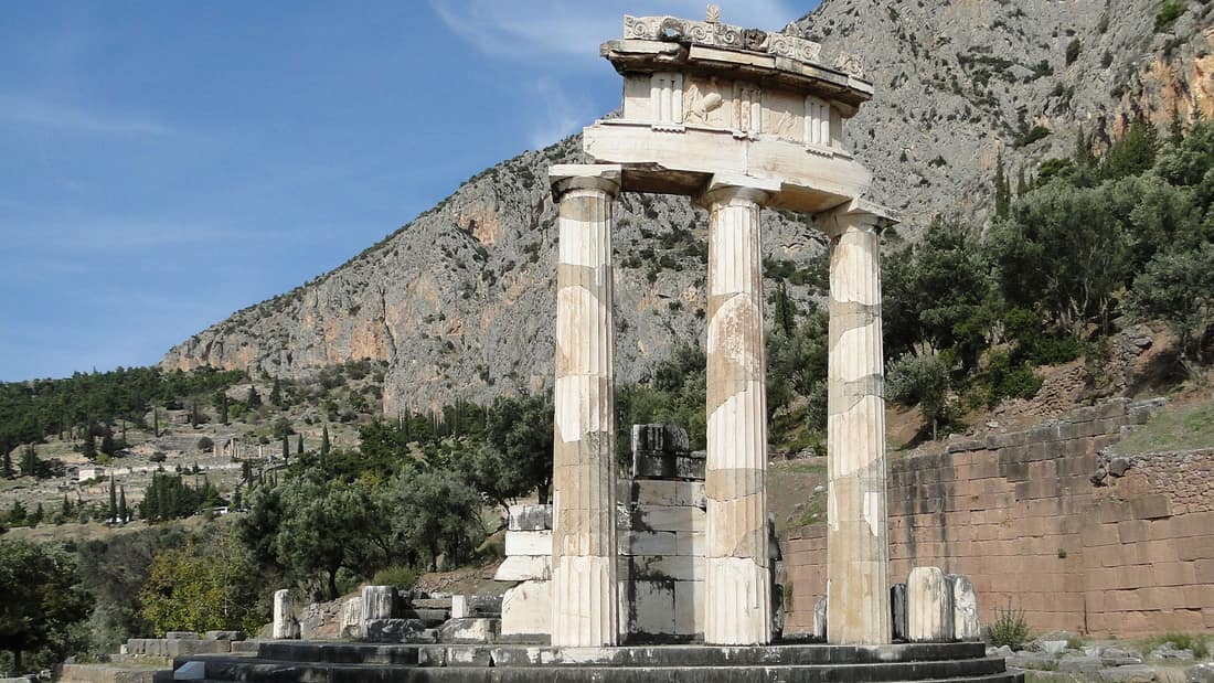 A Delphi Meteora tour begins at the marble columns of the Tholos below the cliffs of Mount Parnassus