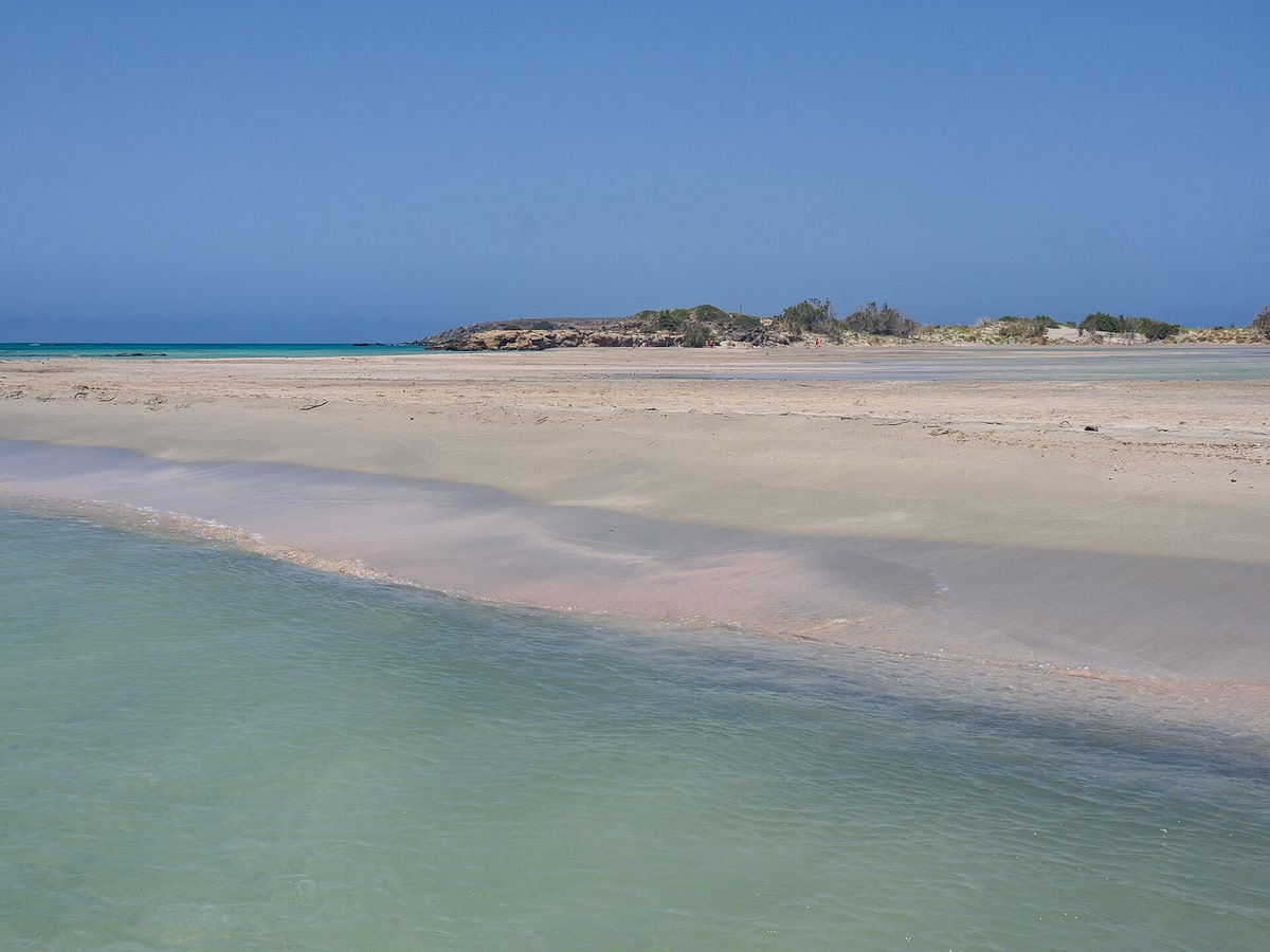 An Elafonisi day trip walks on the pale pink sand by the shallow lagoon