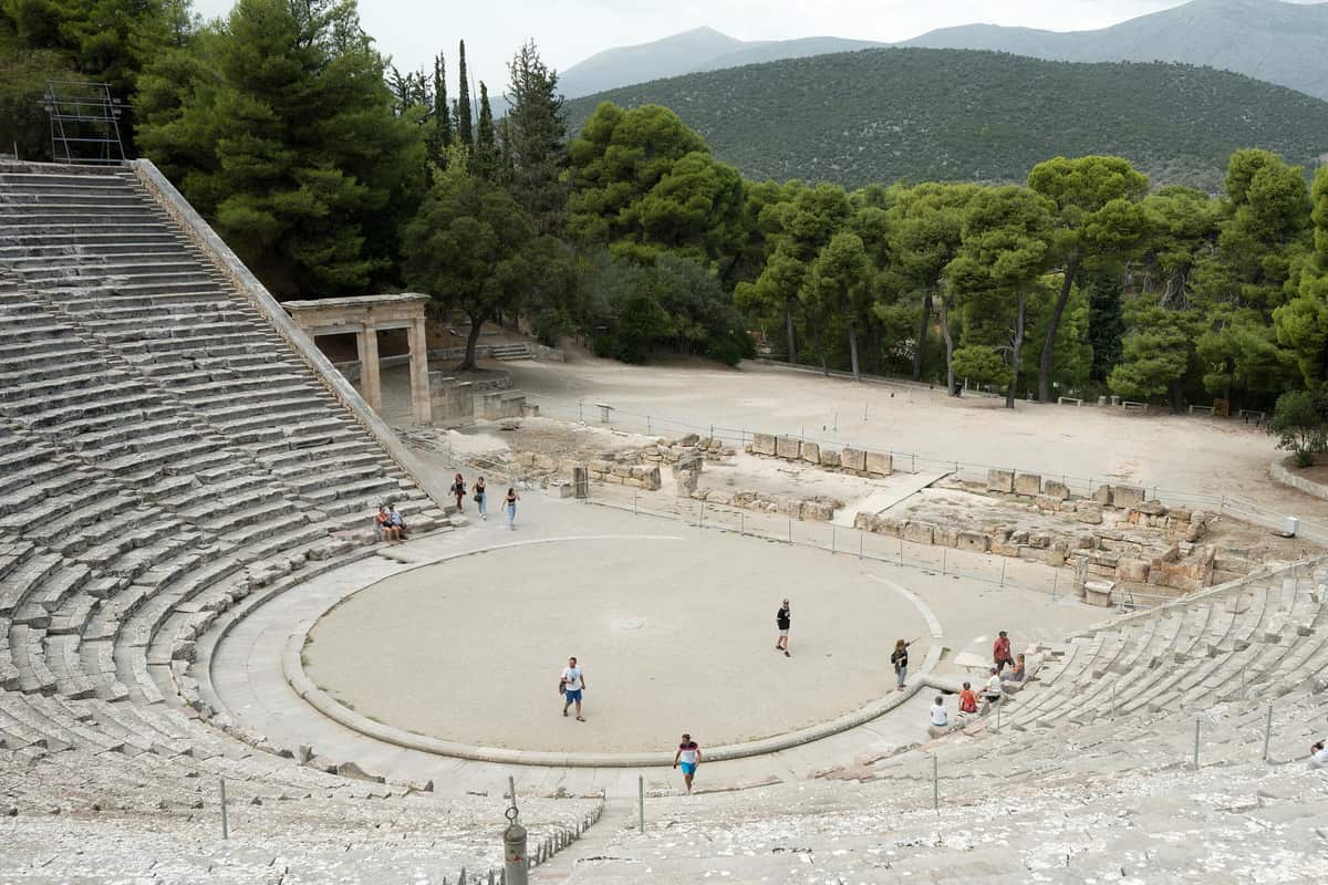 An Epidaurus tour looks down the stone tiers of the ancient theatre to its round orchestra among the pines