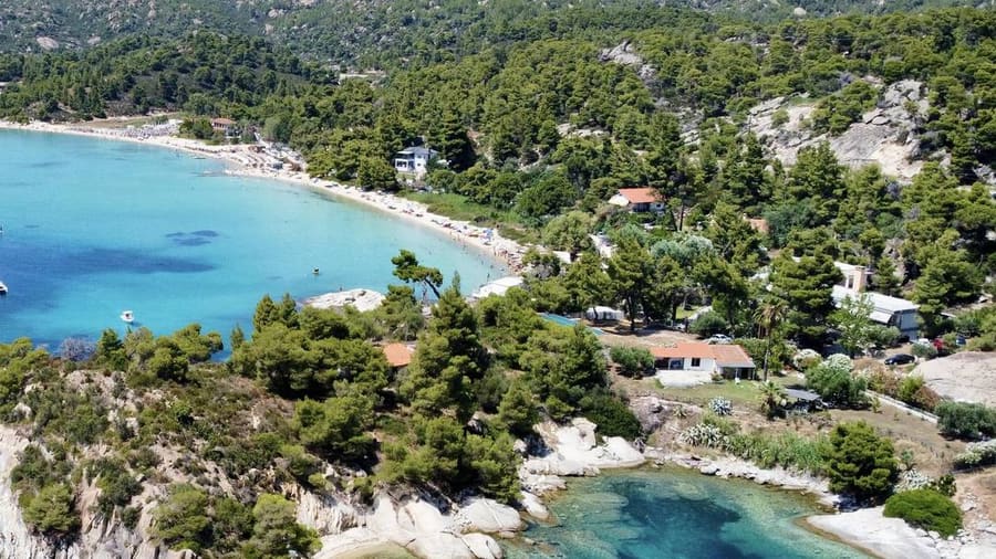 Turquoise bay and pine-covered headland on the Sithonia coast, a stretch passed on a Halkidiki sunset cruise