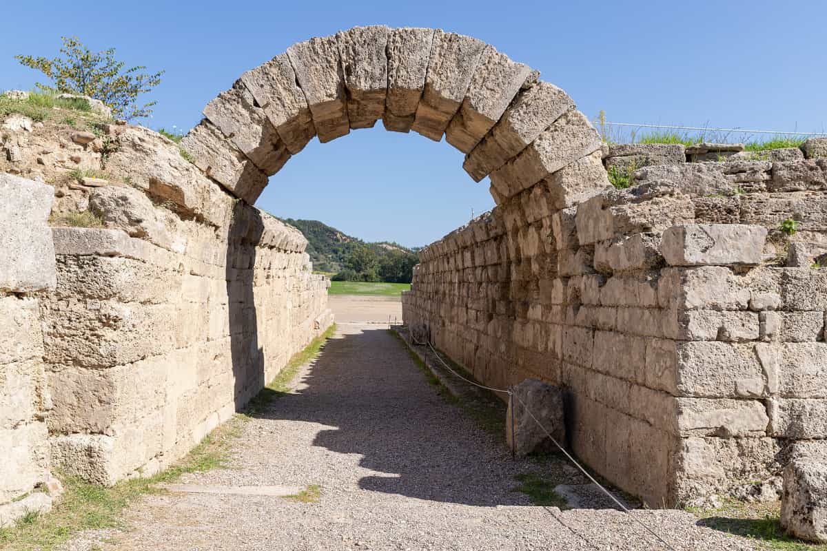 A Katakolon shore excursion walks through the vaulted stone entrance to the ancient stadium of Olympia