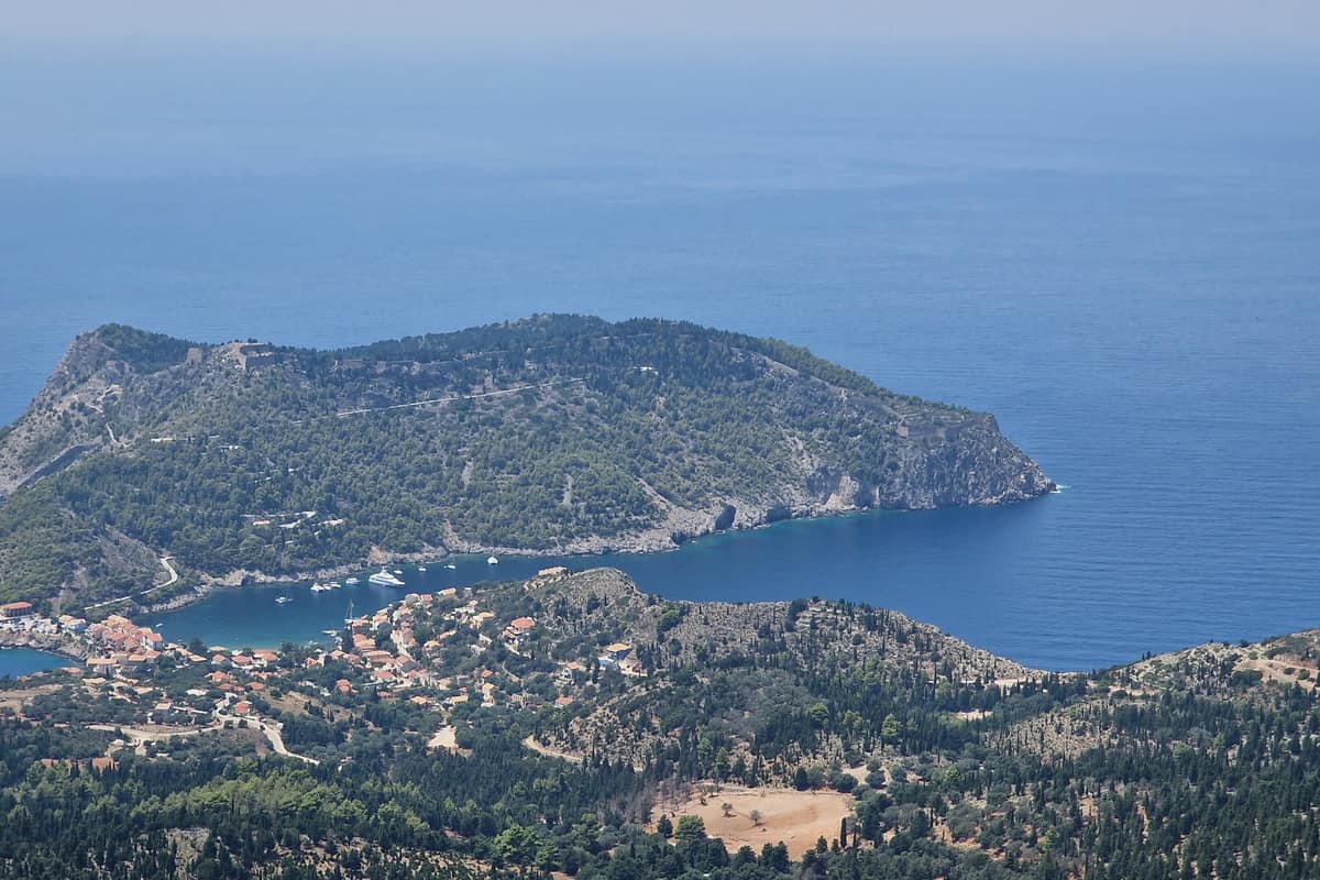 A Kefalonia island tour looks down on Assos, a village below the wooded peninsula of its Venetian castle