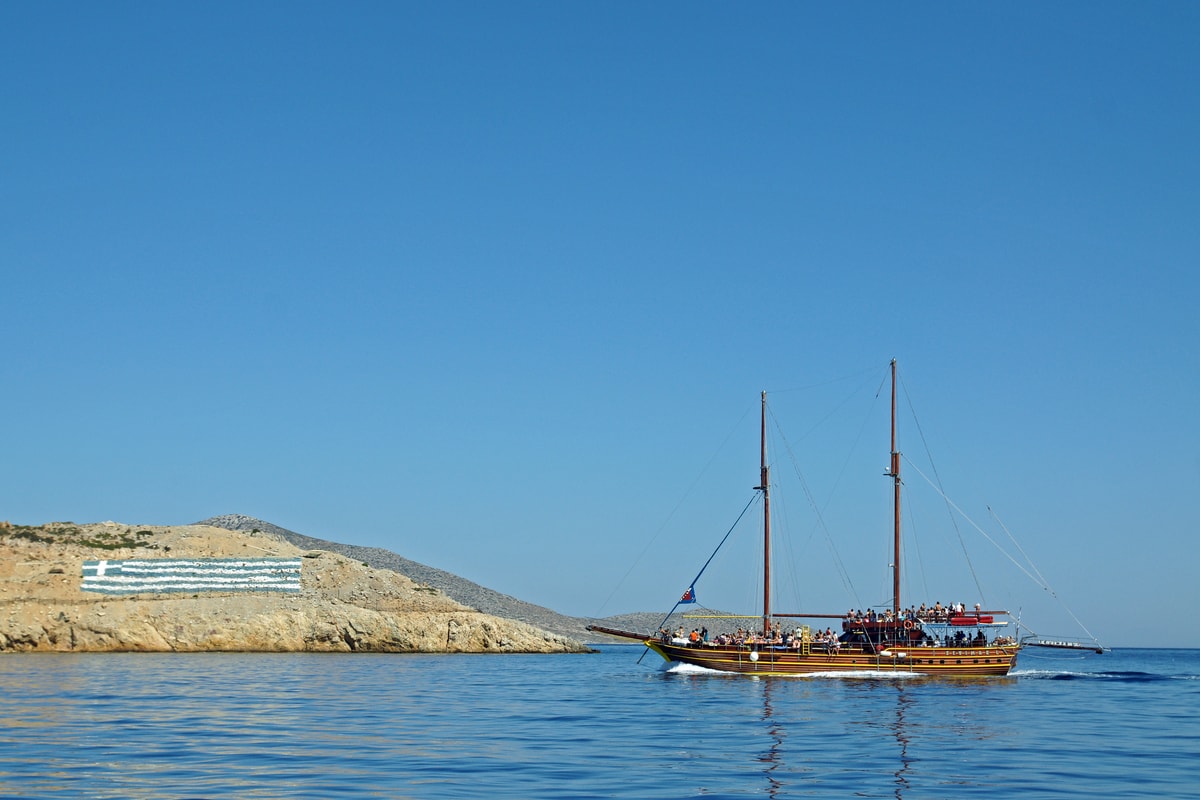 A Kos boat trip on a wooden two-masted boat flying the flag of Greece