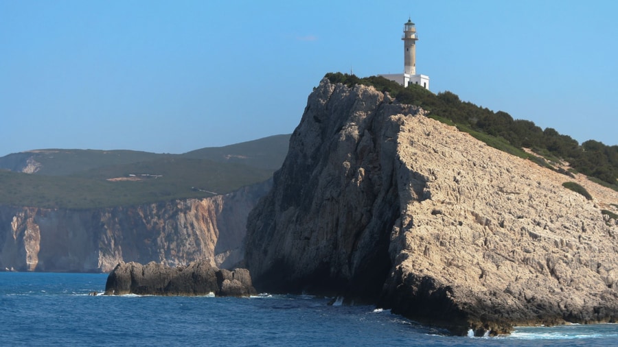 A Lefkada island tour reaches Cape Lefkatas, where the lighthouse stands on white cliffs at the southern tip of the island
