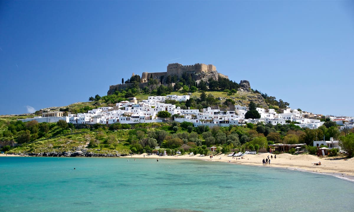 A Lindos tour sees the white village and the acropolis of Lindos above the bay