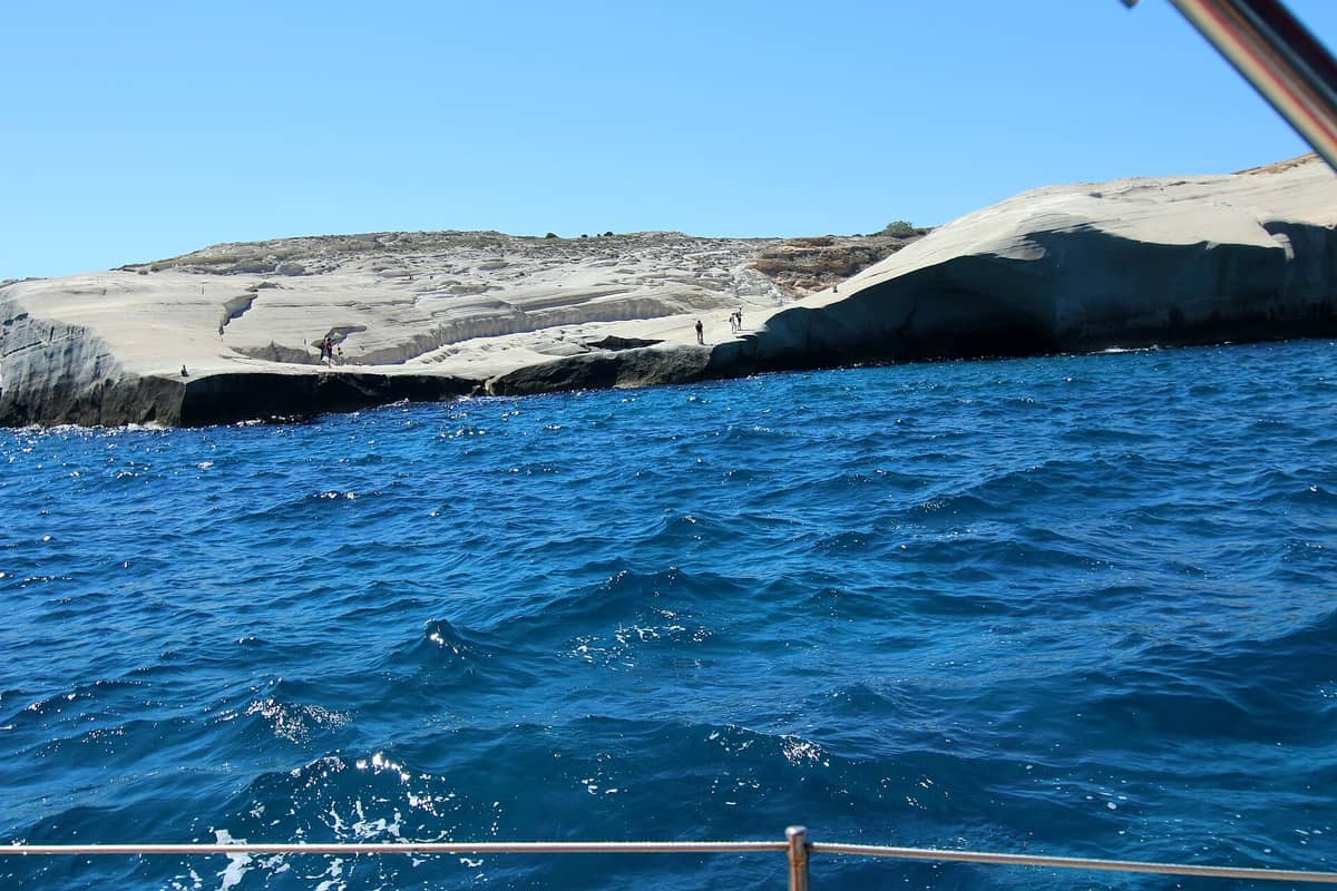 A Milos boat tour passes the white rocks of Sarakiniko from the sea