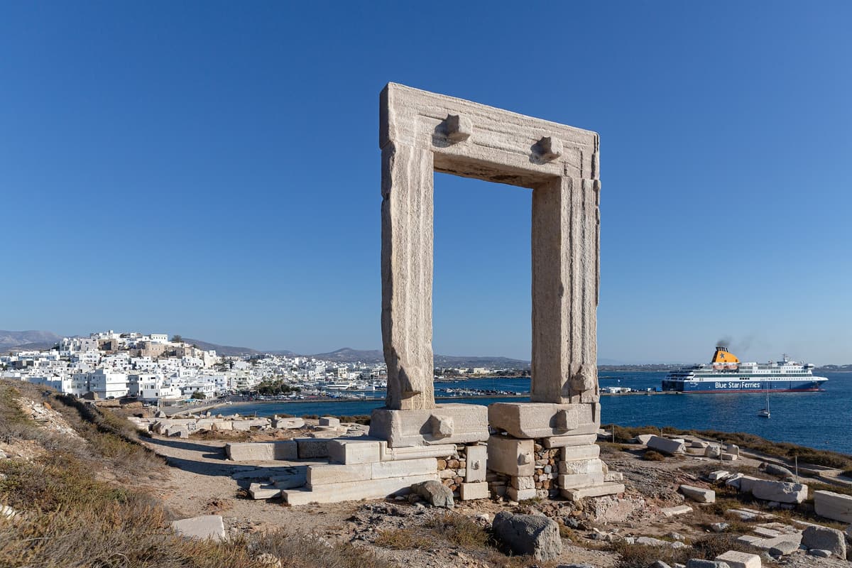 A Naxos boat trip sails past the marble Portara gate above the harbour of Naxos town