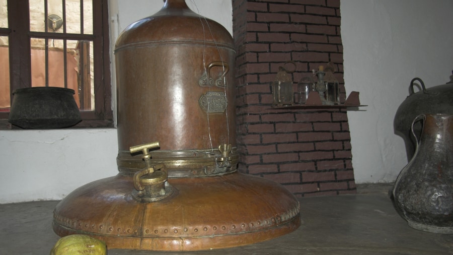 A Naxos food tour visits the kitron distillery in Halki, where an old copper still stands beside a citron fruit