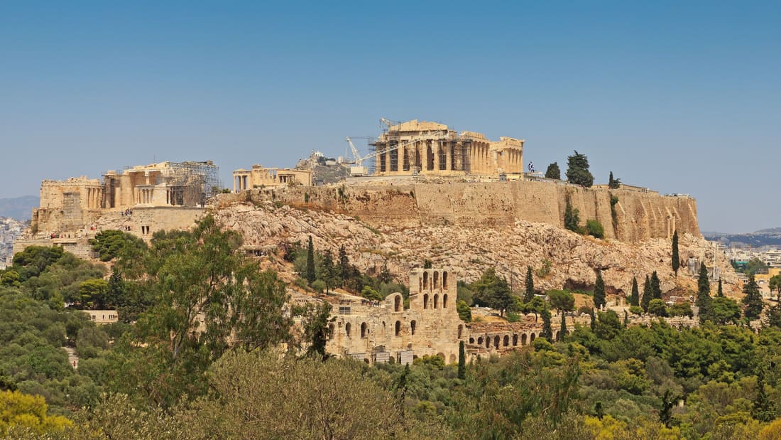 A Piraeus shore excursion heads for the Acropolis of Athens, seen above the pines from Philopappos Hill