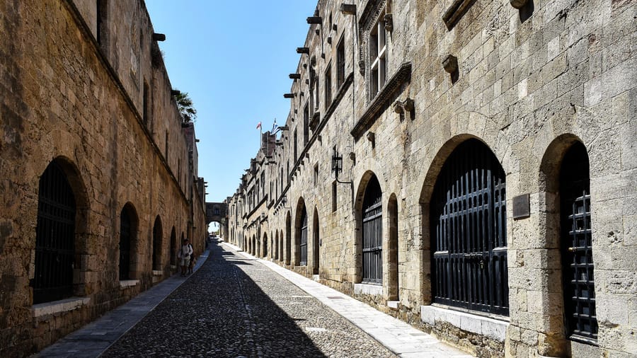 A Rhodes old town tour walks the cobbled Street of the Knights between the stone inns of the Order