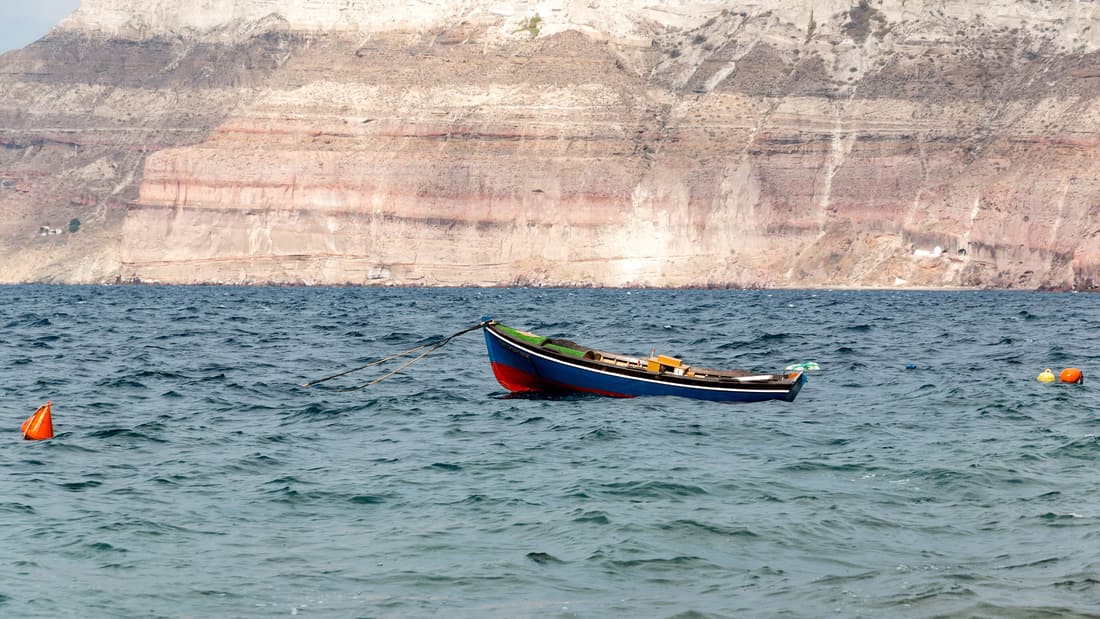 Santorini scuba diving runs below the layered volcanic walls of the caldera, which drop straight into deep water