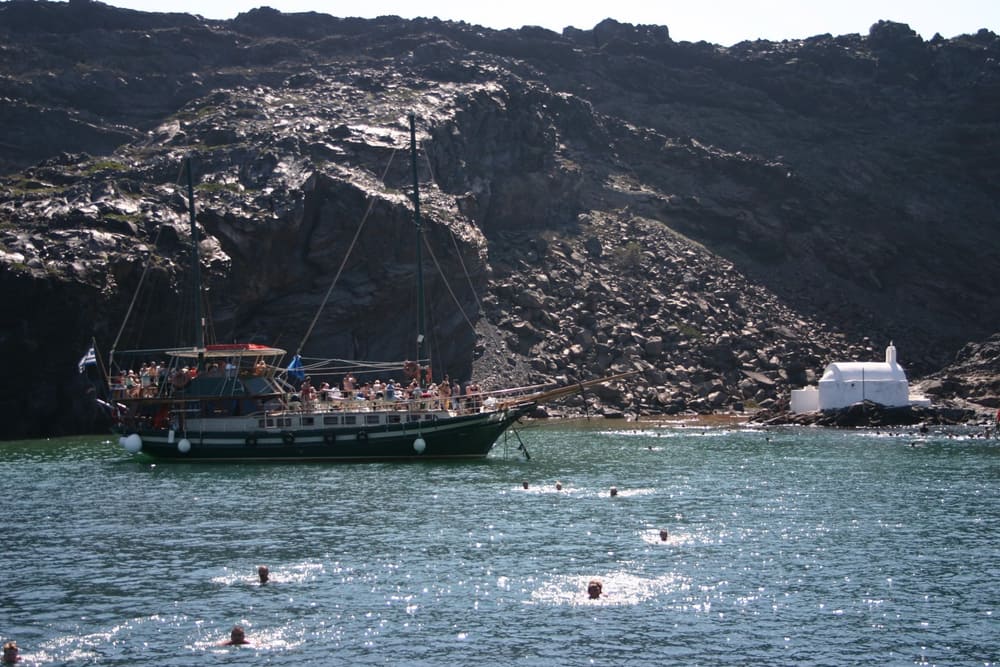 A Santorini volcano tour anchors in the bay of the warm springs at Palea Kameni