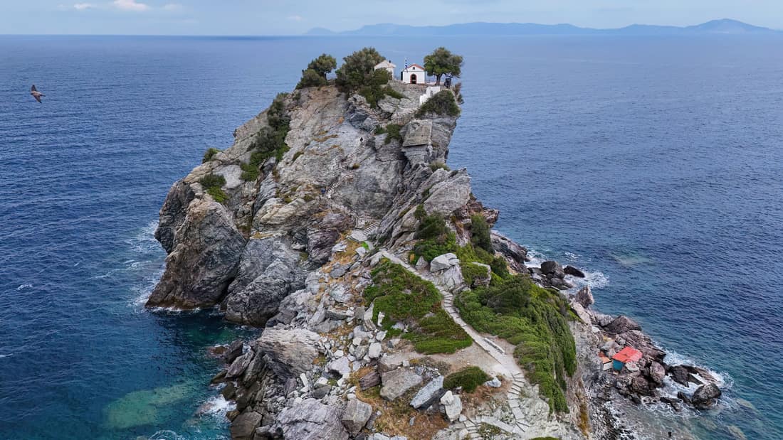 A Skopelos boat trip passes the chapel of Agios Ioannis on top of its rock above the sea