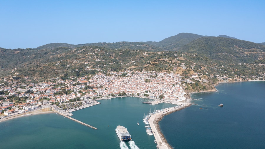 A Skopelos boat trip sails into the harbour below the white houses of Skopelos town