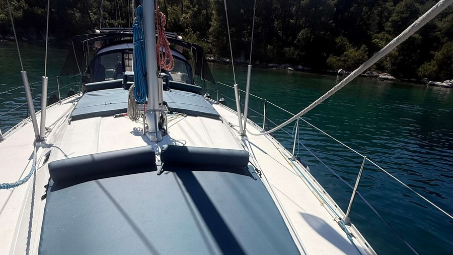 Deck of a sailing yacht at anchor in a quiet pine-fringed bay on a Skopelos sailing tour