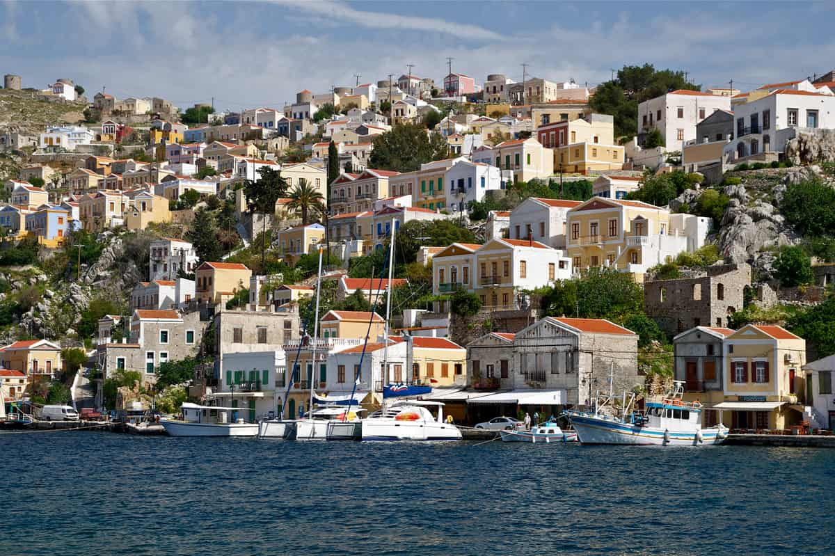 A Symi day trip from Rhodes sees the neoclassical houses above Symi harbour