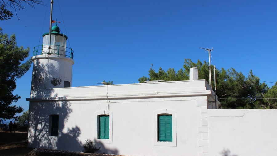 A Zakynthos island tour stops at the white Keri lighthouse among the pines at the southern tip of the island